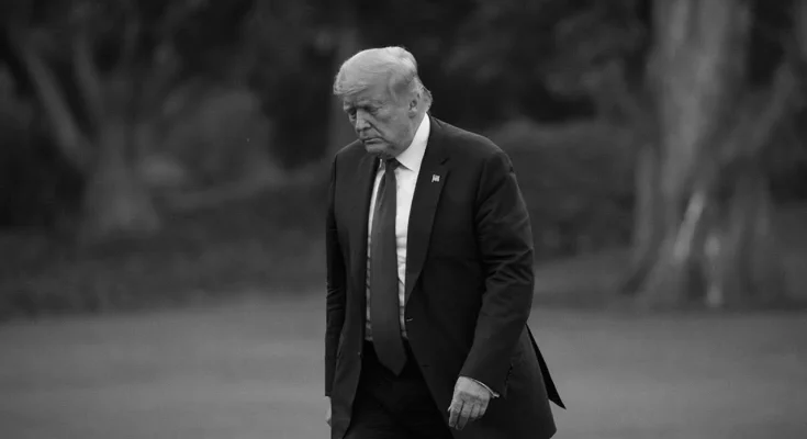 Somber looking Trump, walking head down